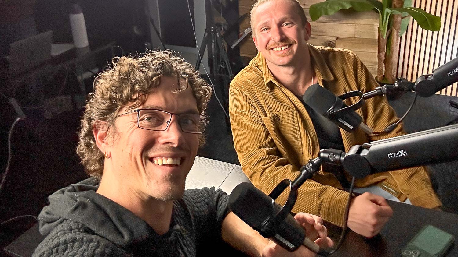Photo of Taylor Johnson and friend in a podcast recording studio.